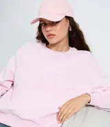 Buzo de algodón con felpa, color rosado, con cuello redondo, mangas largas y puños y bajo en rib. Presenta un estampado localizado en el pecho.