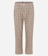 Pijama largo de dos piezas confeccionado en tejido Peach Touch con tacto suave. La blusa presenta escote en V con detalle de encaje y mangas cortas, mientras que el pantalón cuenta con un corte regular. Ambas piezas poseen un estampado abstracto en tonos tierra.