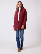 Campera capitoneada de largo midi en color bordó, con diseño de rombos en el cuerpo y mangas, y costuras diagonales en los laterales. Cuenta con cierre frontal, capucha desmontable con interior suave y panel entallado en la cintura.