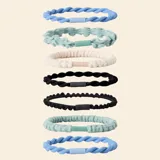 Pack de siete elásticos para el pelo con diferentes texturas y diseños, incluyendo estilos trenzados y con volados, en una variedad de colores que incluye azul, verde, beige y negro.