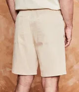 Bermuda masculina color gris claro, de sarga con efecto jaspeado, cintura elástica ajustable con cordón, bolsillos laterales y traseros, y etiqueta en la barra.