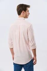 Camisa de lino a rayas finas en tonos beige y blanco, de manga larga con puños vueltos, cuello camisero y cierre frontal de botones. Cuenta con un pequeño logo bordado en el pecho.