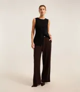 Pantalón recto color marrón chocolate, confeccionado en crepé, con trabillas en la cintura, cinturón con hebilla y pliegues.