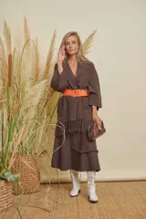 Saco largo color chocolate con cuello en V, mangas anchas y detalle de flecos en el ruedo. Se ajusta con un cinturón ancho color naranja.