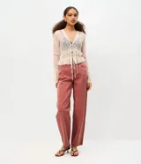 Pantalón baggy de sarga de algodón color rosado, con cintura media, bolsillos funcionales y ajuste mediante botón y cierre.