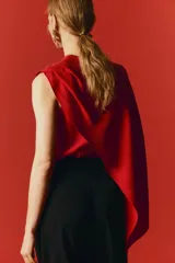 Blusa roja sin mangas en mezcla de viscosa, con escote redondo y diseño asimétrico de efecto capa con pliegues en un lateral.