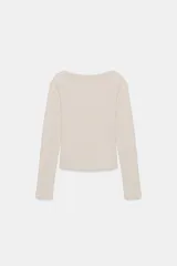 Camiseta de manga larga con cuello barco y bajo recto, confeccionada en tejido de punto liso.