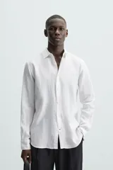 Camisa de corte regular fit confeccionada en tejido de lino, con cuello solapa, manga larga con puños abotonados y cierre frontal de botones.
