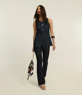 Pantalón bootcut de tiro alto confeccionado en denim azul oscuro, con cierre de botón y cremallera, trabillas en la cintura y bolsillos delanteros y traseros.