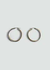 Aros de diseño bicolor, combinando tonos dorados y plateados en una estructura circular de tamaño mediano con cierre de tanca.