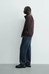 Cazadora azul marino de corte regular fit, confeccionada en tejido técnico repelente al agua. Presenta cuello subido, manga larga, bolsillos de vivo en cadera, bolsillo interior y acabados en rib en puños y bajo. Cierre frontal de cremallera oculta por solapa con botones a presión.