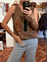 Chaleco marrón de tela agamuzada con apliques cortados y bordados a mano. Diseño sin mangas con cuello en V.