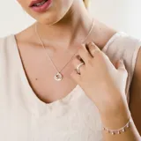 Anillo en forma de V fabricado en plata 925, con engaste de pequeñas circonias brillantes a lo largo de la banda.
