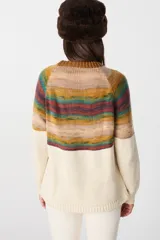Sweater de tejido de punto con diseño artístico de un árbol en la parte inferior y franjas horizontales multicolores en la parte superior. Presenta cuello redondo, mangas largas y puños acanalados.