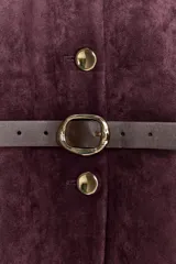 Blazer de cuello redondo y manga larga, confeccionado en tejido efecto ante. Presenta cierre frontal con botones, bolsillos con tapeta en el pecho y cinturón ajustable en la cintura.