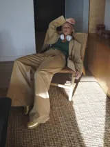 Pantalón beige de corte ancho con pinzas y bolsillos laterales.