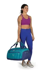 Bolso tipo duffel de la marca Osprey, color negro, con gran apertura frontal en forma de U, bolsillos laterales con cierre y asas versátiles para llevar al hombro o como mochila.