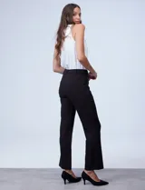 Pantalón negro de tejido elastizado, corte recto con ligero ensanchamiento en el bajo, pretina con pasadores y apliques de eco cuero en los bolsillos delanteros.