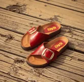 Sandalias rojas con base de corcho y hebilla dorada con el logo de la marca.
