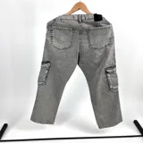 Pantalón jean cargo gris claro, corte recto, con bolsillos laterales rectangulares y bolsillos traseros.