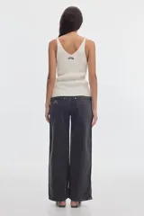 Musculosa de tejido rib color negro, con escote en pico y tirantes finos.