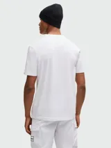 Camiseta blanca de algodón elástico con cuello redondo y manga corta. Presenta un estampado artístico con el logo de la marca en el pecho.