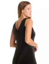 Vestido midi negro de terciopelo, con escote redondo cerrado en la parte delantera y escote en V profundo en la espalda. Sin mangas, con pinzas de entalle laterales y corte que se abre ligeramente hacia el ruedo.