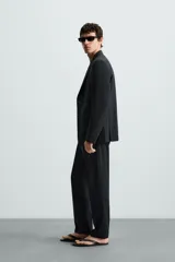 Blazer de corte regular fit confeccionado en tejido con lana. Presenta cuello con solapas de muesca, cierre frontal de dos botones, manga larga con puños abotonados, bolsillo de vivo en el pecho y bolsillos con solapa en la cadera.