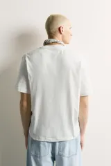 Camiseta de corte relaxed fit, confeccionada en mezcla de algodón y lino, con cuello redondo y mangas cortas.