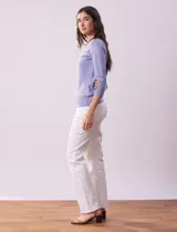 Buzo color rosa de tejido combinado con detalle de botones en las mangas y cuello redondo.