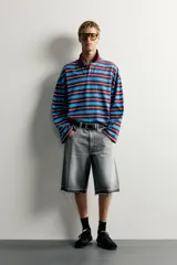 Polo de manga larga con diseño de rayas horizontales en tonos bordó, celeste y blanco, de corte relaxed fit, con cuello tipo polo y cierre frontal de botones.