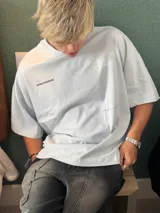 Remera celeste de corte holgado con estampado en la espalda que dice "Ittai Stars" en letras cursivas y "An Ibiza Produce" en mayúsculas.