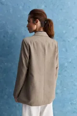 Blazer de corte recto y silueta relajada, de color tostado, con solapas clásicas y bolsillos con solapa en los laterales.