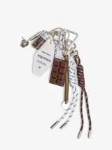 Llavero con dije de barra de chocolate, llavero de motel con la inscripción "AQUAGEM", frasco de vidrio con granos de café, cordones trenzados en blanco y marrón, y mosquetones metálicos.