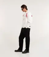 Saco deportivo boxy de algodón felpa color blanco, con cuello redondo, manga raglán larga y recortes rojos en los hombros. Presenta bordados frontales con texto "OFFICIAL NATIONAL MAJOR HARMONY", un logo circular y el número "31". Las mangas tienen un patrón de cuadros rojos y blancos.