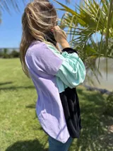 Polerón oversize con bloques de color lila, verde agua y negro.