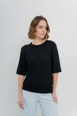 Buzo de tejido abierto color beige claro, de calce oversize con mangas 3/4 y cuello redondo. Presenta terminaciones acanaladas en puños y cintura.