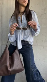 Camisa celeste de tejido liviano y calce relajado, con delicado bordado geométrico en el frente, mangas amplias con puños fruncidos y cierre frontal de botones.