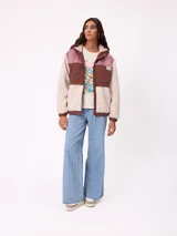 Campera con capucha de diseño combinado en bloques de color. Presenta una sección superior en pana rosada, una franja central en nylon marrón con logo de la marca y cuerpo inferior y mangas en tejido sherpa color crema. Incluye cierre frontal y bolsillos laterales.