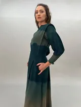 Vestido largo verde con efecto degradado, mangas largas abullonadas y falda con tajos laterales.