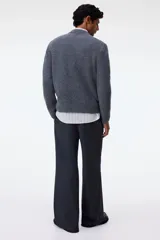 Buzo de punto color gris oscuro, con cuello redondo y acabado cepillado. Presenta remates acanalados en cuello, puños y bajo.