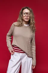 Sweater de tejido de punto color tostado, con cuello redondo a la base, manga larga y detalles de tramas tipo ochos en las mangas y laterales.