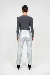 Pantalón de tiro medio confeccionado en eco cuero con acabado metalizado color plata, de corte recto y diseño clásico con bolsillos laterales y traseros.