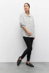 Pantalón chupín elastizado negro con cierres laterales y costuras a lo largo de ambas piernas.