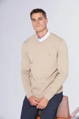Buzo de tejido de hilo liviano color beige, con escote en V y logo bordado en el pecho.
