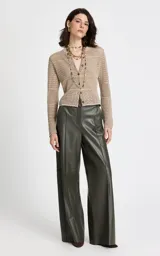 Cárdigan de punto beige con diseño calado y texturizado. Presenta cuello redondo, mangas largas y cierre frontal con botones a tono.