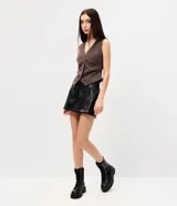 Short pollera de poliuretano color marrón, con diseño que imita el cuero, cintura con trabillas, bolsillos delanteros y bolsillo lateral estilo cargo.