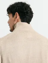 Sweater de punto inglés color verde, con cuello alto y cierre frontal parcial metálico. Diseño de manga larga con puños y ruedo acanalados.