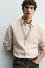 Camisa celeste de lino de corte regular fit, con cuello abotonado, manga larga y cierre frontal de botonadura.