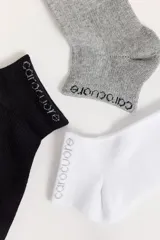 Pack de tres pares de medias tipo soquete de algodón peinado, con logo de la marca bordado en el puño. Incluye un par negro, uno blanco y uno gris melange.